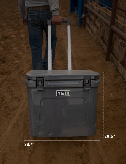 YETI cooler being pulled on a dirt ground with dimensions displayed