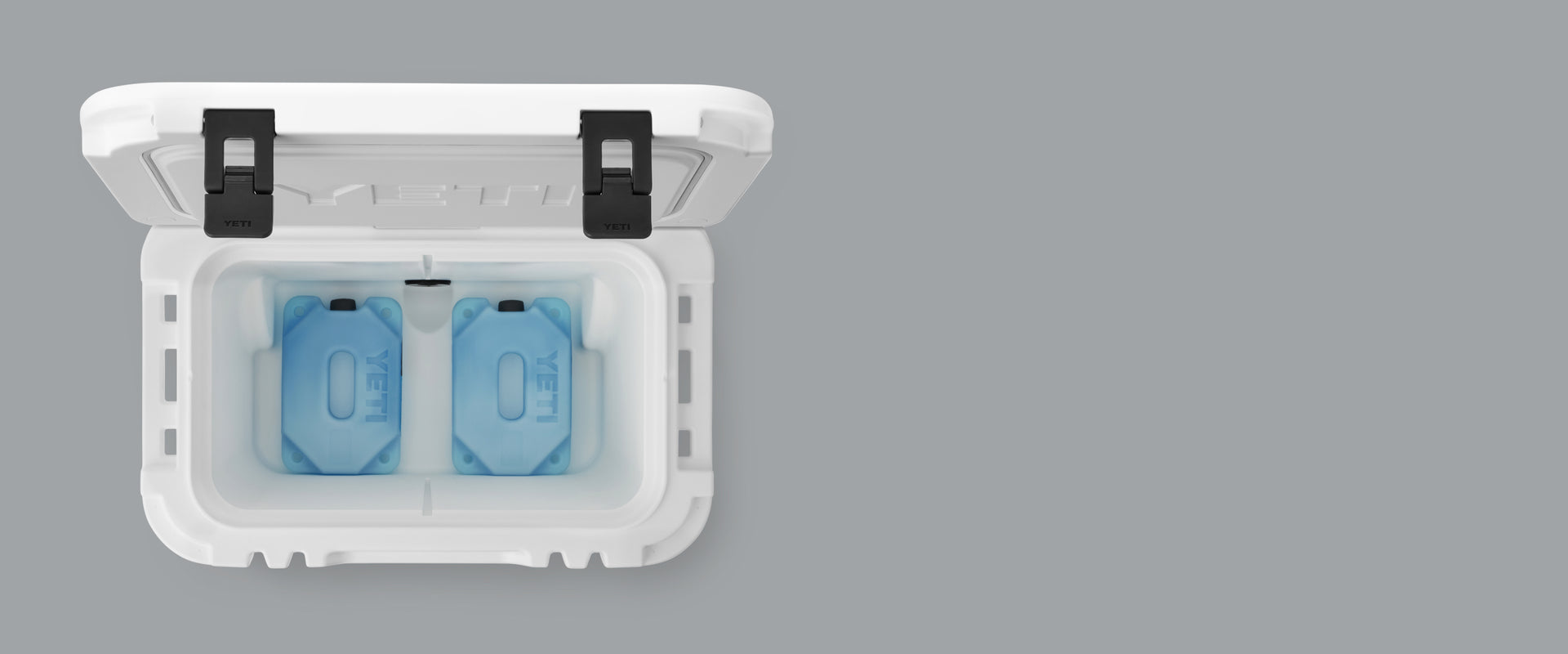 White cooler box with two blue ice packs on a gray background