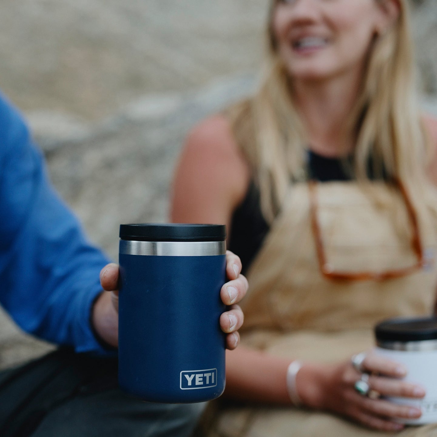 Person holding a YETI branded mug with coffee