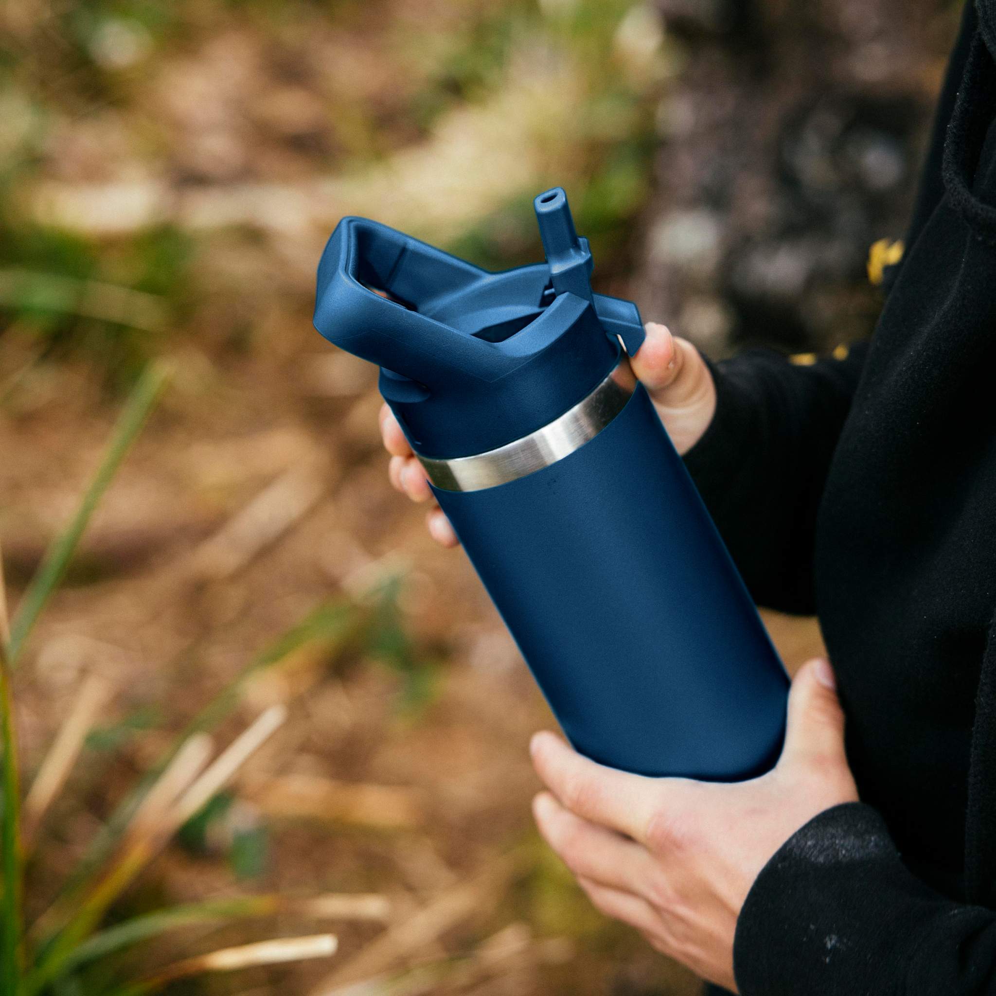 Person holding a YETI branded mug with coffee
