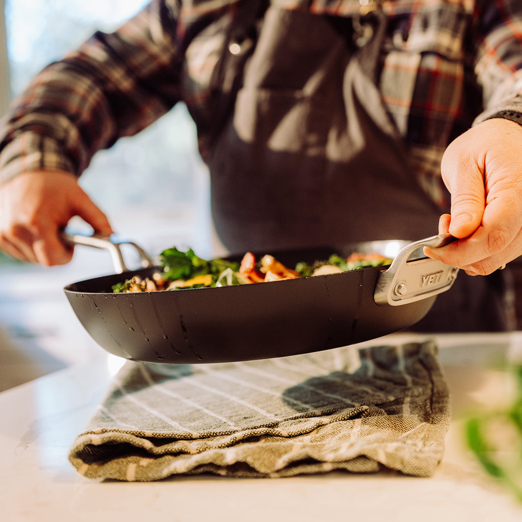 Person holding a YETI pan with food on a kitchen counter
