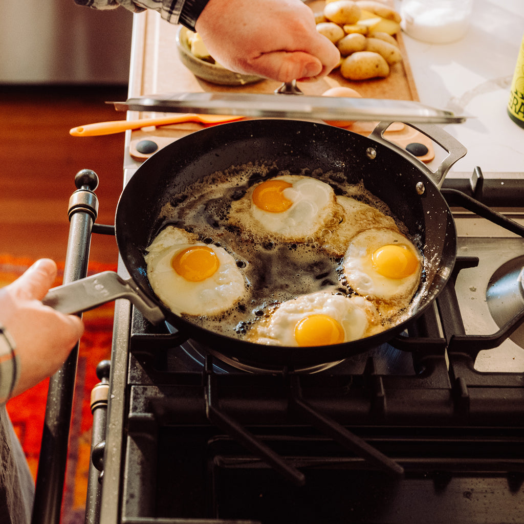 YETI frying pan with eggs on a stove, person cooking