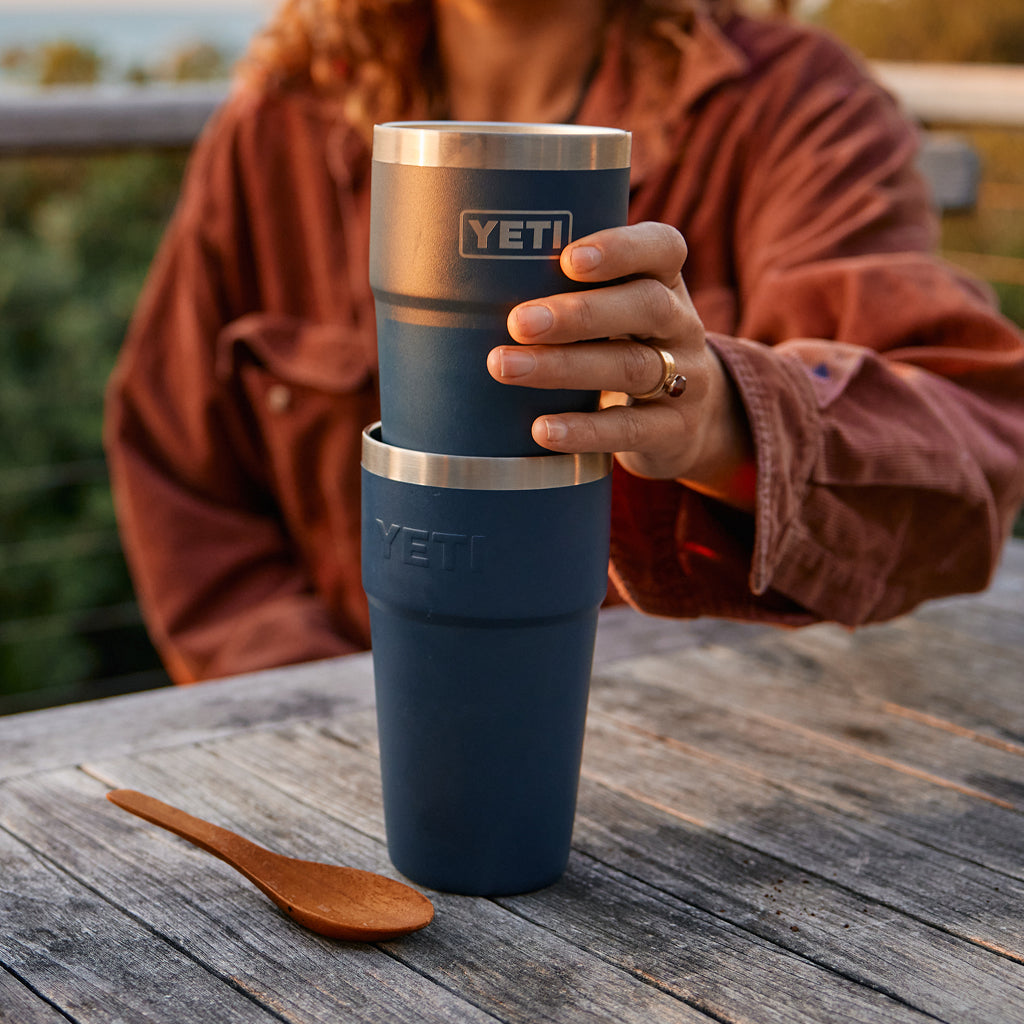 Person holding a YETI branded mug with coffee