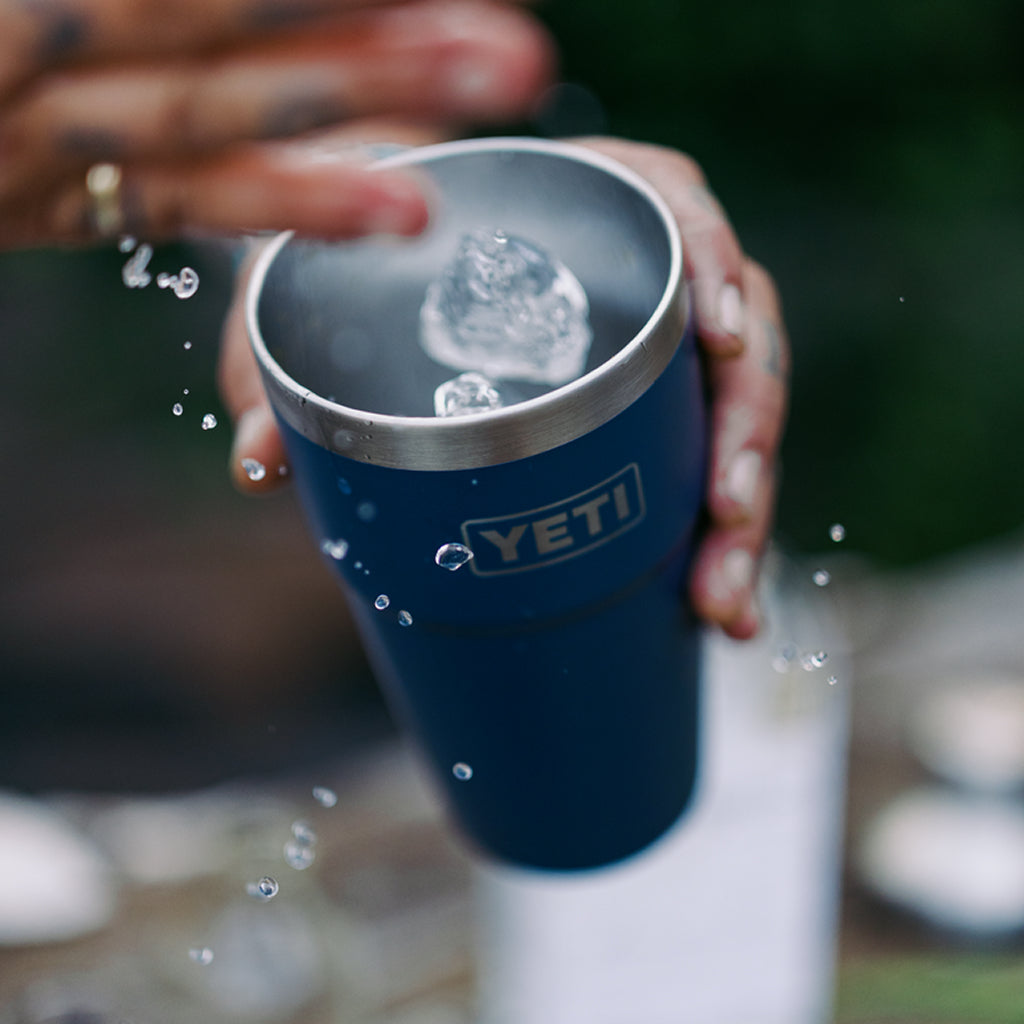 Person holding a YETI mug on a boat