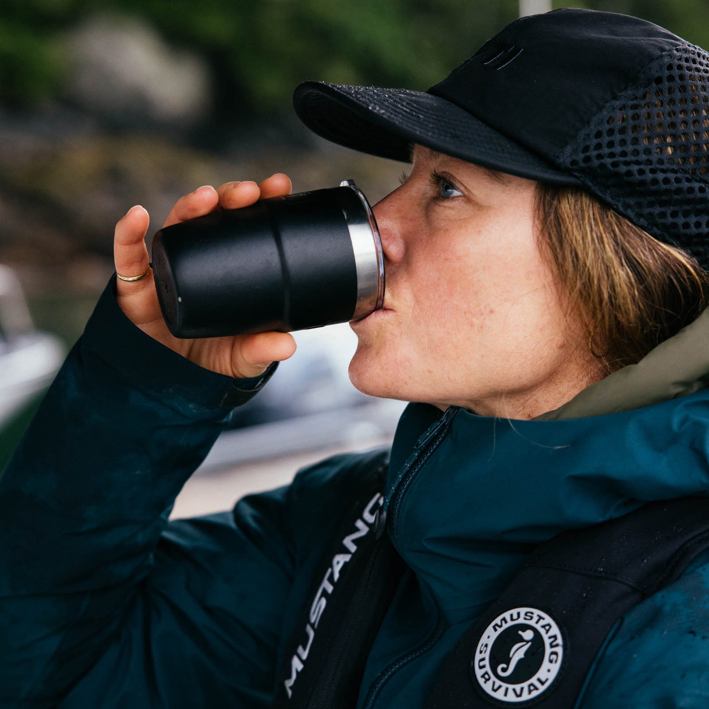 Person holding a YETI mug on a boat