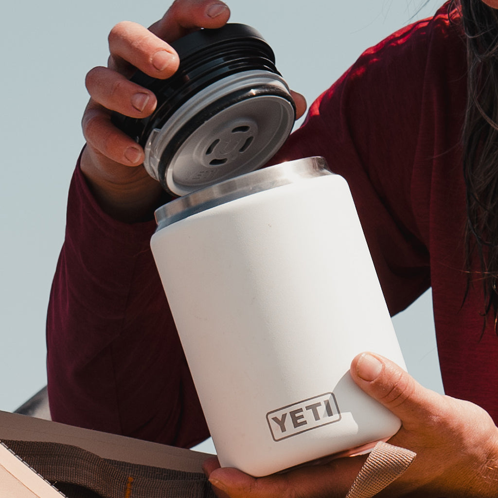 Person holding a YETI branded mug with coffee