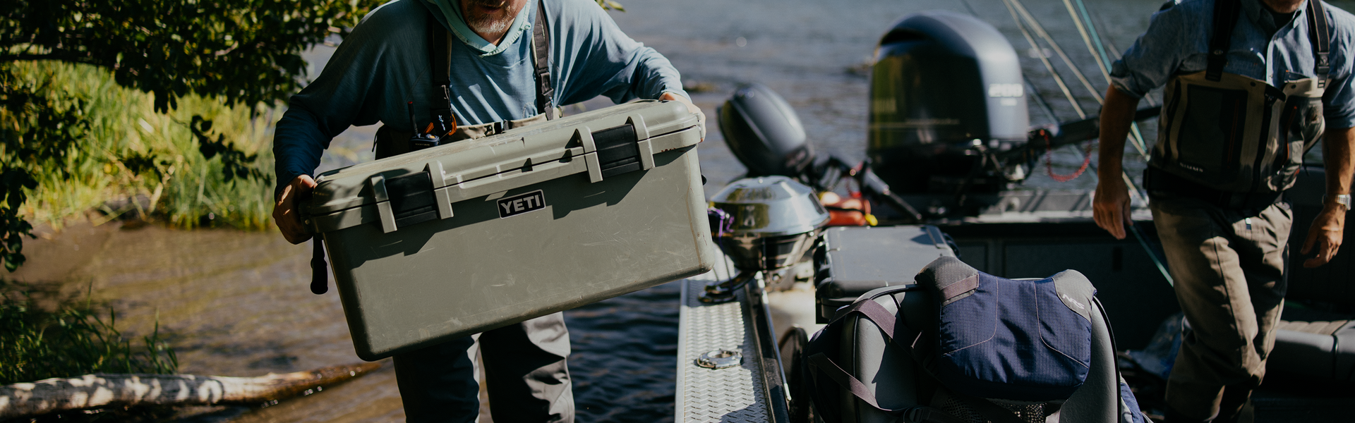 Person carrying a gear case on to a boat.