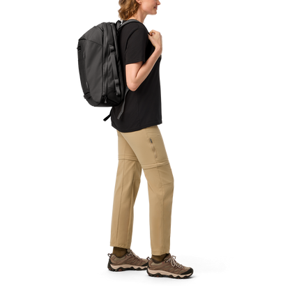 Person wearing a black backpack and beige trousers on a white background