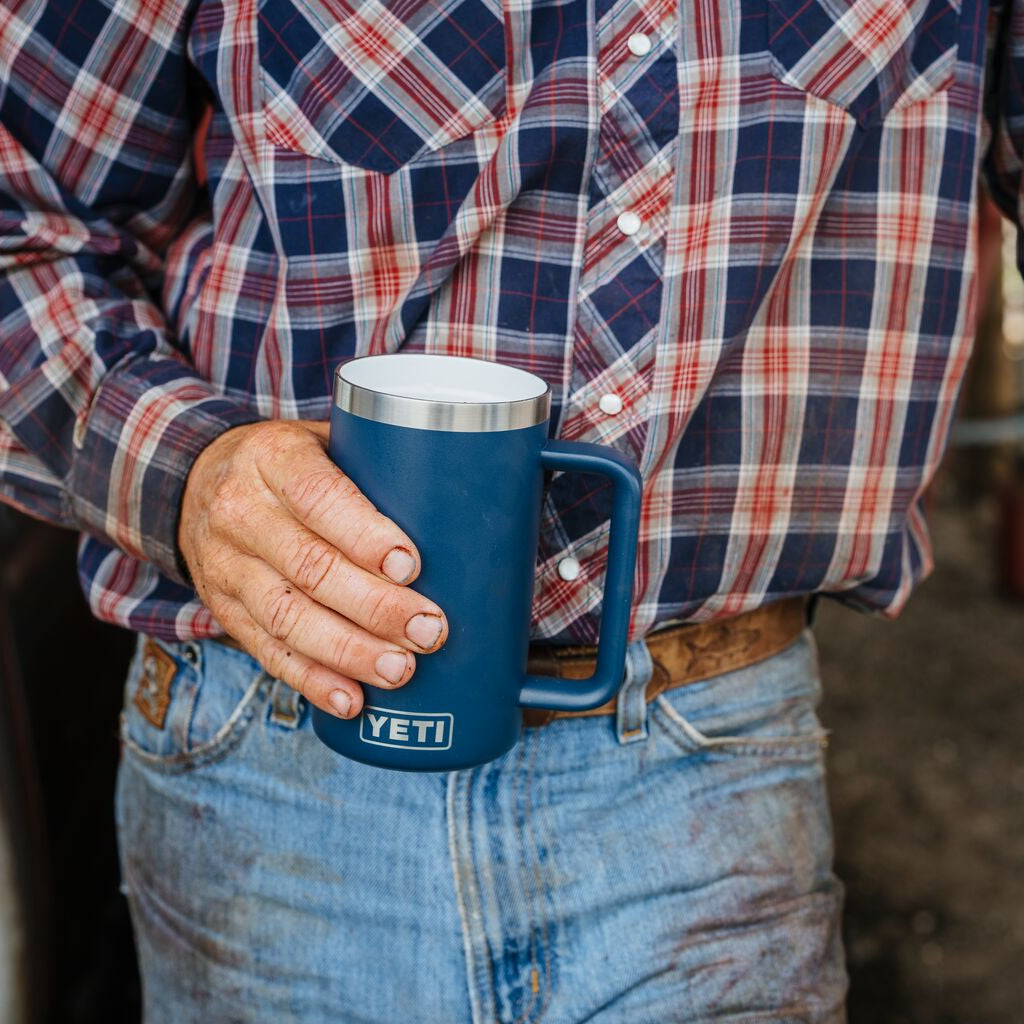 Person holding a blue Yeti mug in an outdoor setting
