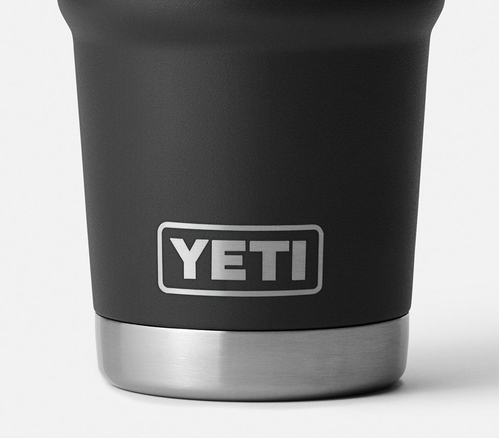 Person holding a YETI branded mug with coffee