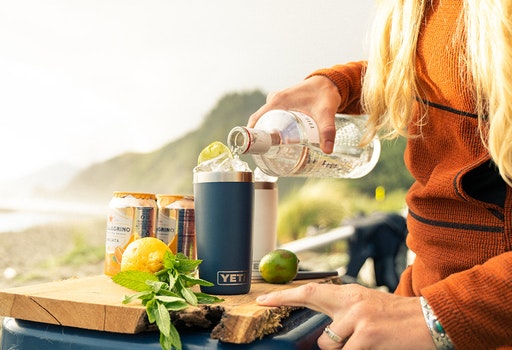Person holding a YETI mug on a boat