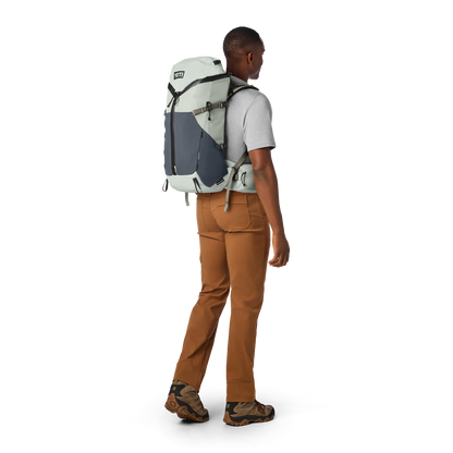 Person wearing a large backpack on a white background