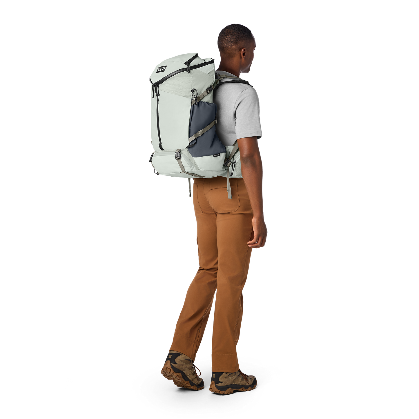 Person wearing a large backpack on a white background