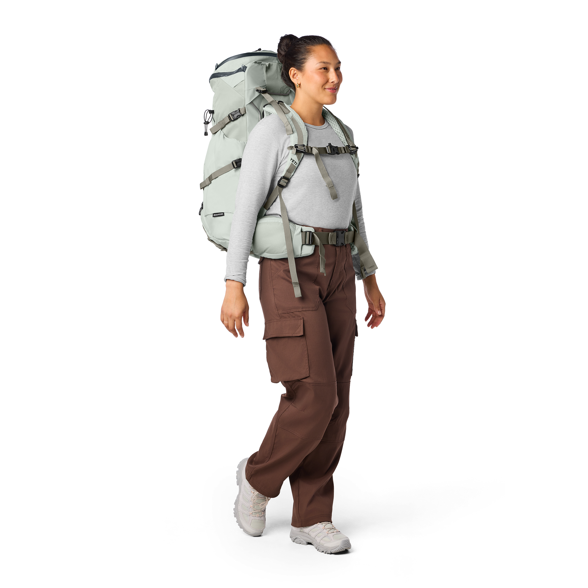 Person wearing a large hiking backpack on a white background