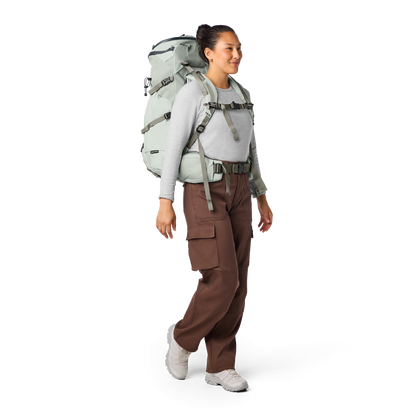 Person wearing a large hiking backpack on a white background