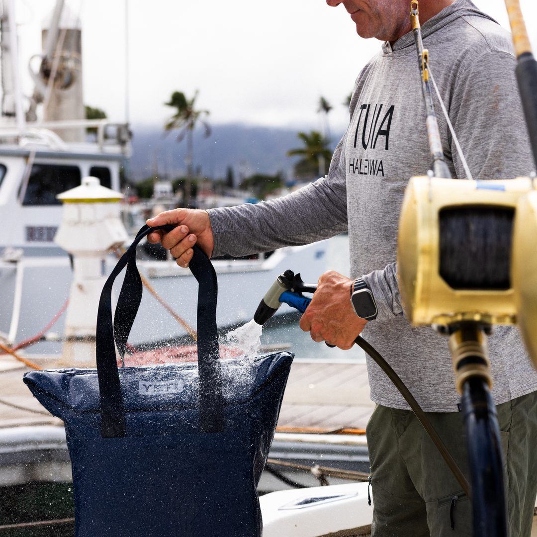 Person at a marina with fishing equipment and a YETI Daytrip bag