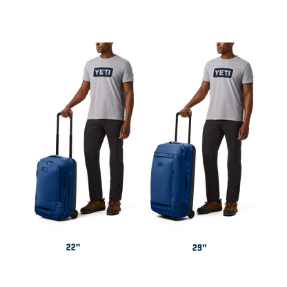 Man holding a blue suitcase with 'YETI' branding on a white background
